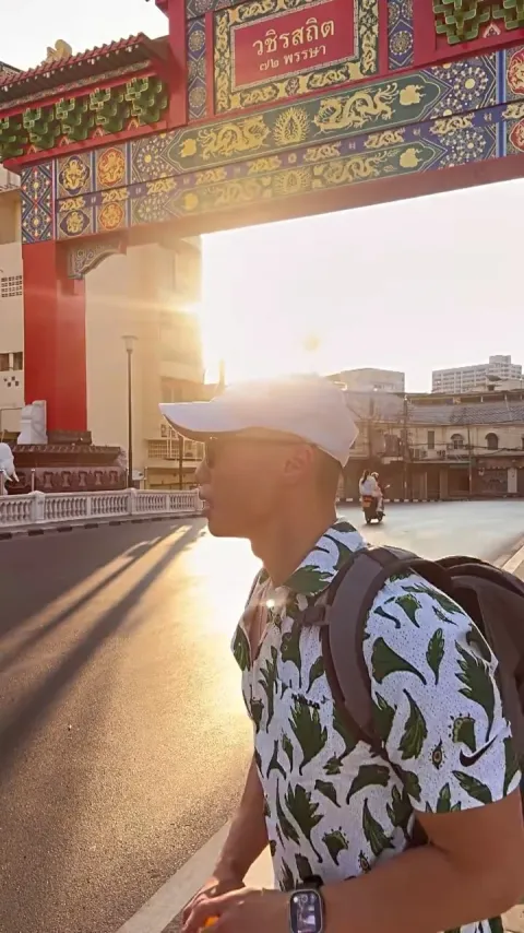 A person walking near a sunlit temple entrance.